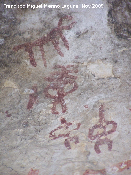 Pinturas rupestres de la Cueva de la Graja-Grupo VIII - Pinturas rupestres de la Cueva de la Graja-Grupo VIII. Cabra o toro, debajo un antropomorfo tipo phi con adorno de asta de ciervo en la cabeza y debajo de este dos antropomorfos tipo phi