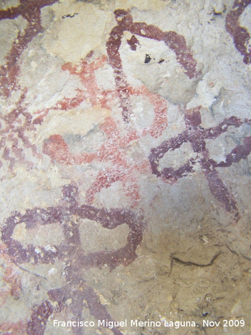 Pinturas rupestres de la Cueva de la Graja-Grupo VIII - Pinturas rupestres de la Cueva de la Graja-Grupo VIII. Antropomorfo de color rojo claro y de tipo phi con dos piernas y falo. Tambin tiene un adorno en la cabeza de tipo barra horizontal