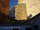 Castillo de Navas de San Juan. Torren circular macizo de mampostera y parte del muro embutidos entre las casas