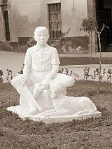 Escultura Golfillo sentado con su perro. Foto antigua