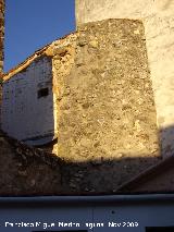 Castillo de Navas de San Juan. Torren circular macizo de mampostera y parte del muro embutidos entre las casas