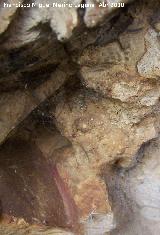 Pinturas rupestres de la Cueva de los Herreros Grupo VIII. Arco con doble flecha y alineaciones de puntos negros, y abajo la barra vertical roja
